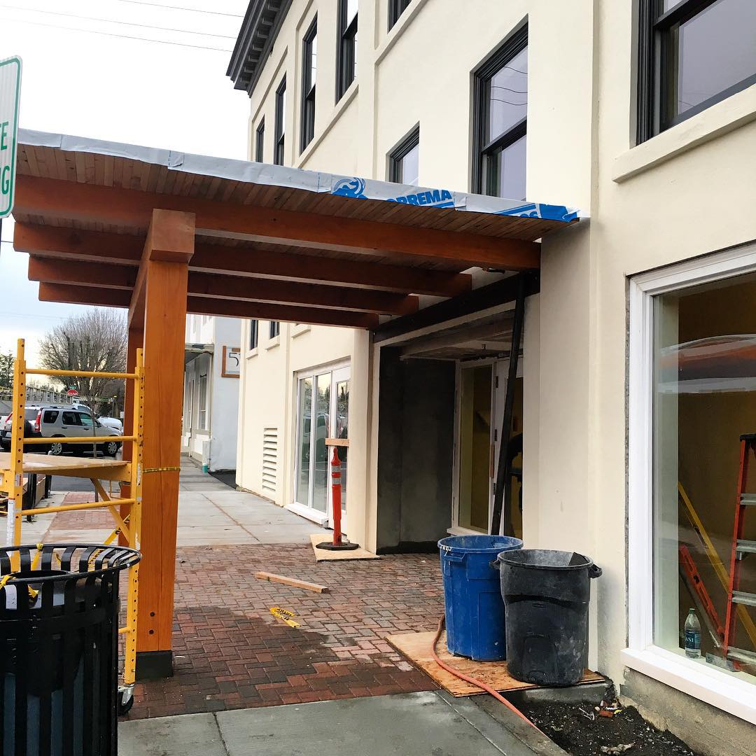 Wood-beam portico extends over the sidewalk of the 5th Street entrance to the Inn at Lynden