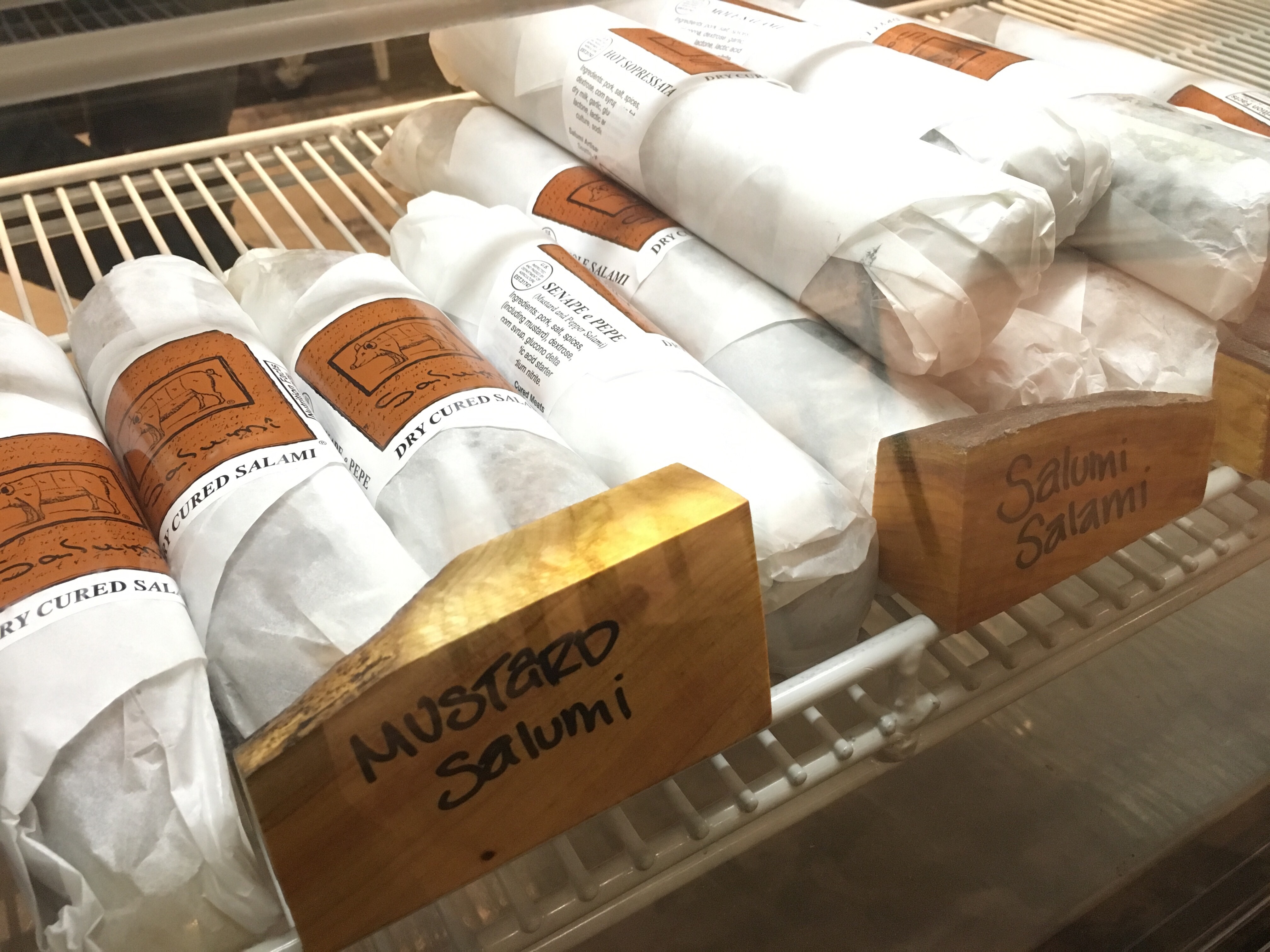 Drizzle offers a variety of fine salumi, cheese and more in their deli case at the rear of the store.